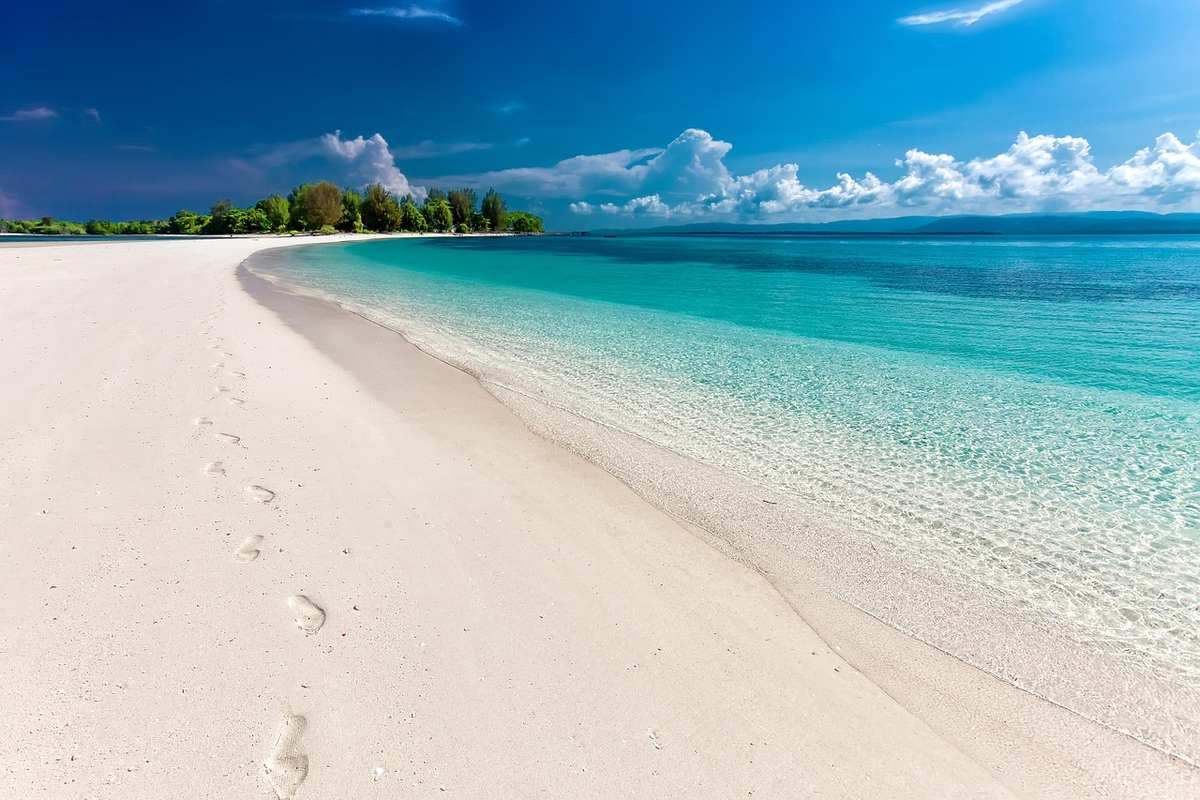 Plage déserte avec eau claire et ciel ensoleillé au-dessus Plage déserte avec eau claire et ciel ensoleillé au-dessus