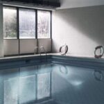 Piscine intérieure avec fenêtres, marche, bouées, eau calme