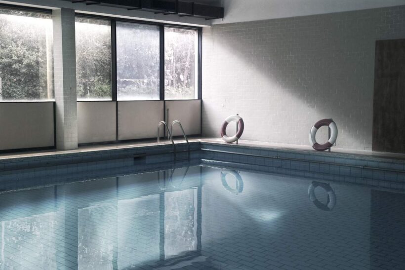 Piscine intérieure avec fenêtres, marche, bouées, eau calme