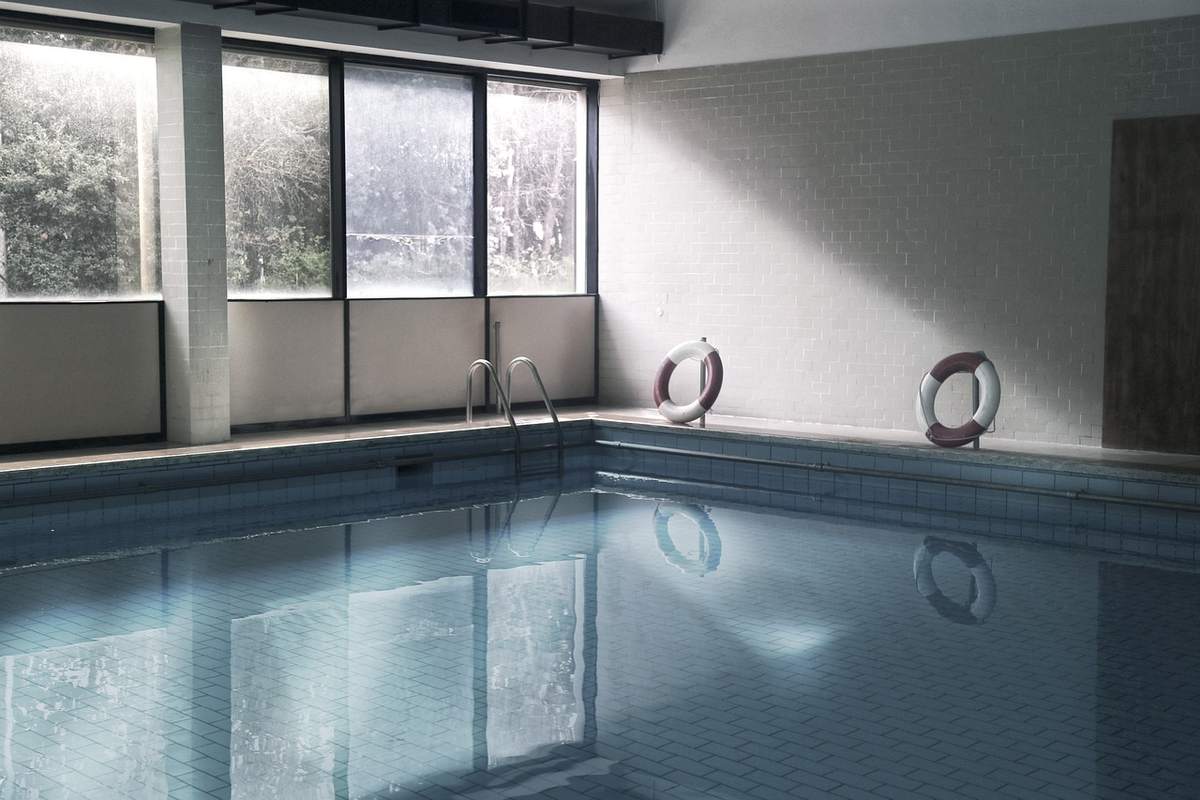 Piscine intérieure avec fenêtres, marche, bouées, eau calme