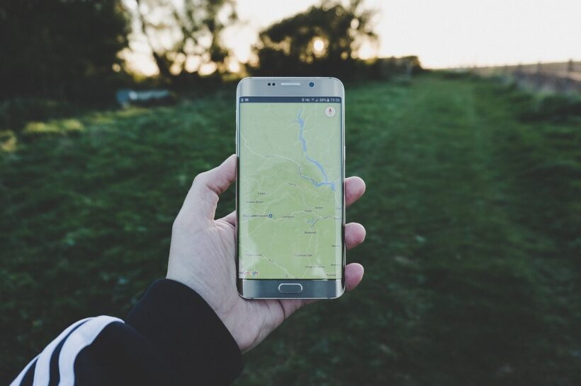 Main tenant un smartphone avec une carte